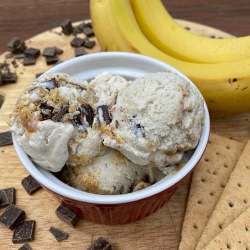 dish of Banana Graham Ice Cream surrounded by graham crackers, chocolate chunks, and bananas