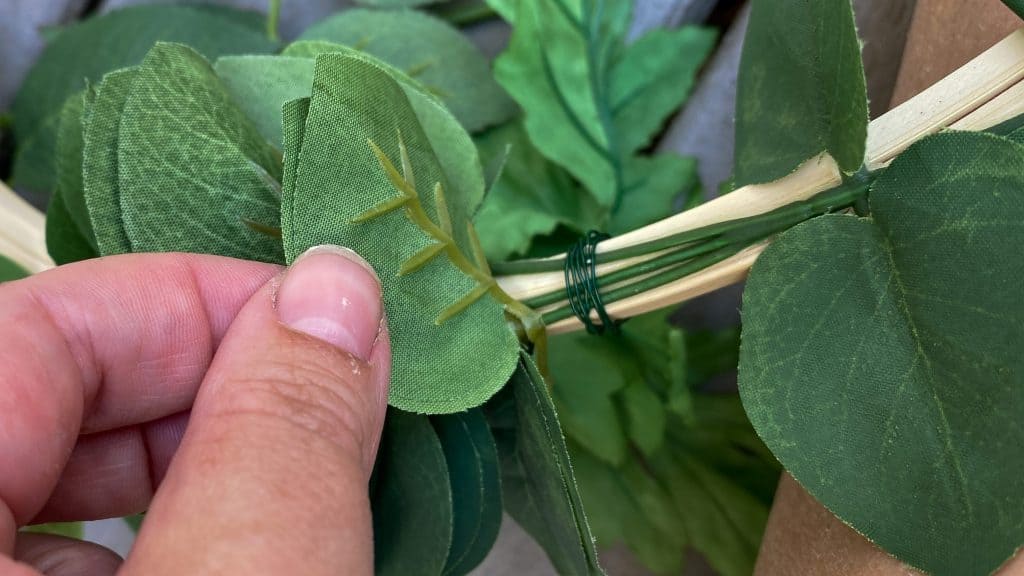 close up of faux greener wrapped with floral wire onto the embroidery hoop