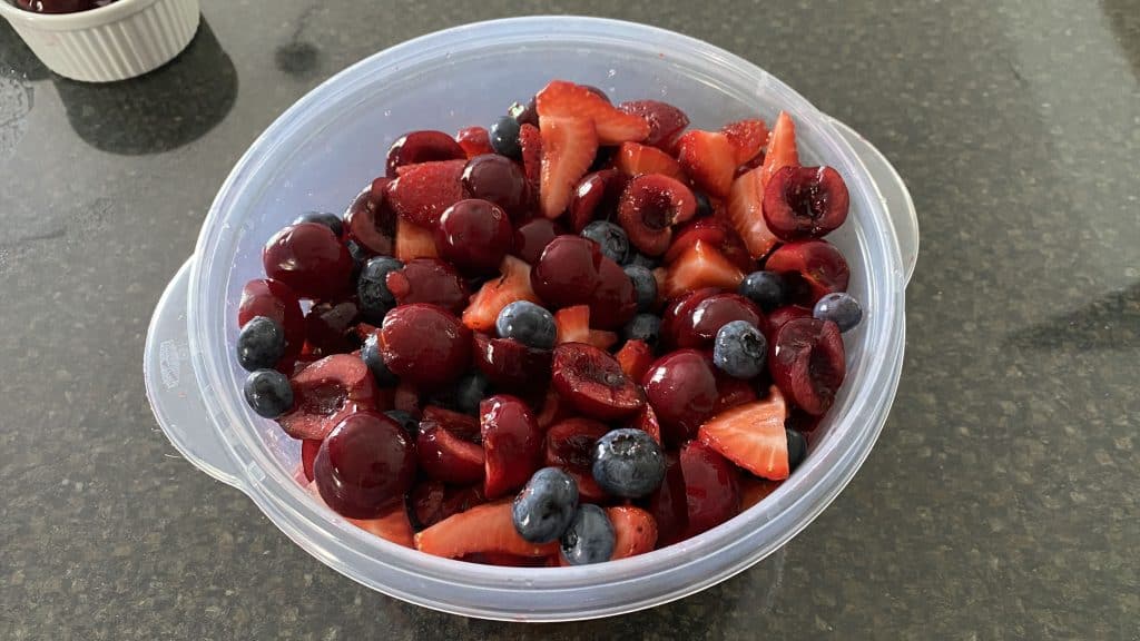 bowl with cut up cherries, strawberries, and blueberries