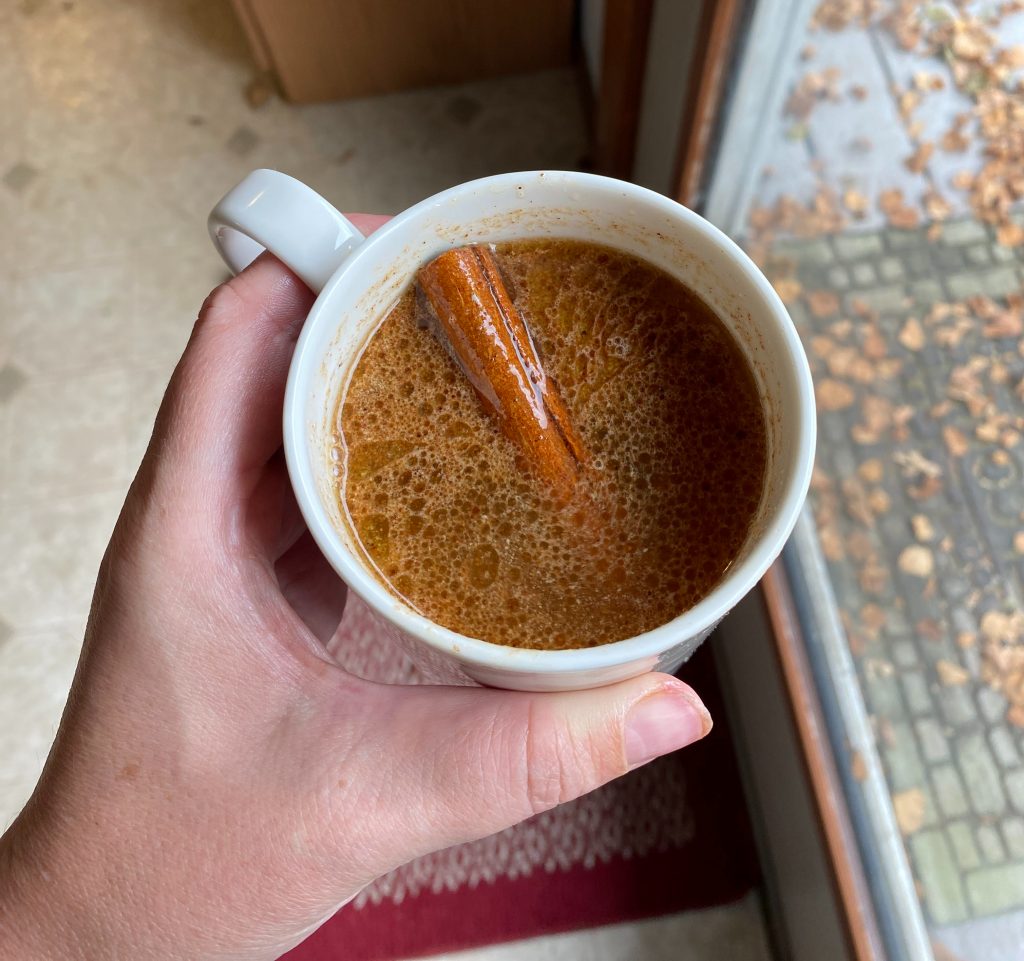 mug with hot buttered rum cider and a cinnamon stick garnish