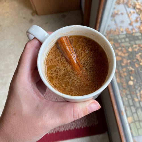 mug with hot buttered rum cider and a cinnamon stick garnish