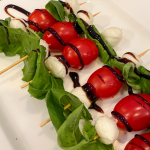 pin image with closeup of mini caprese skewers