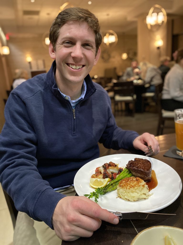 husband of author with a plate of food at a restaurant
