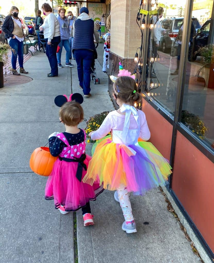 two little girls trick or treating in costumes