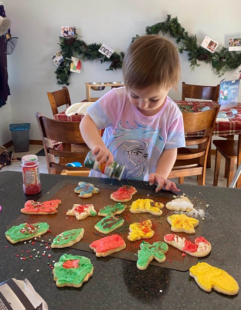 child decorating Christmas cookies