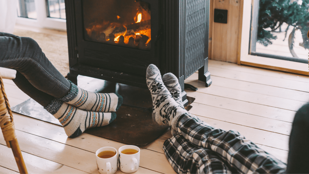 feet in front of fire with mugs of hot chocolate on the floor
