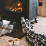 feet in front of fire with mugs of hot chocolate on the floor