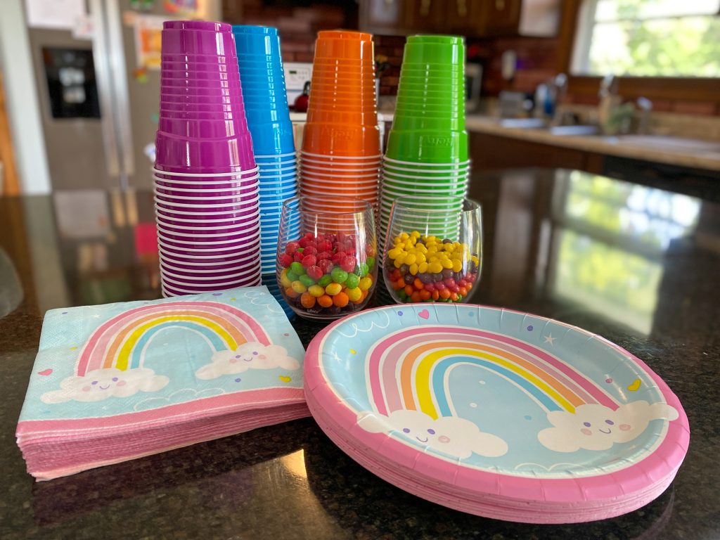 rainbow plates and napkins plus cups in colors purple, blue, orange and green