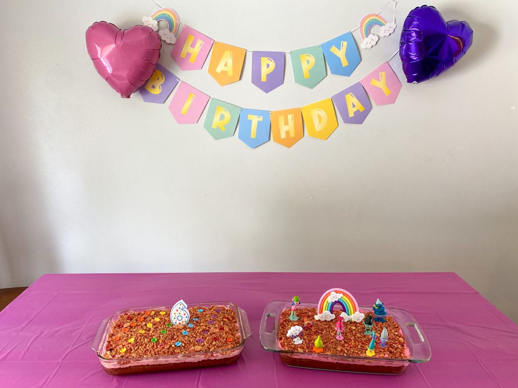 Happy birthday banner with two heart shaped balloons and two cakes on the table