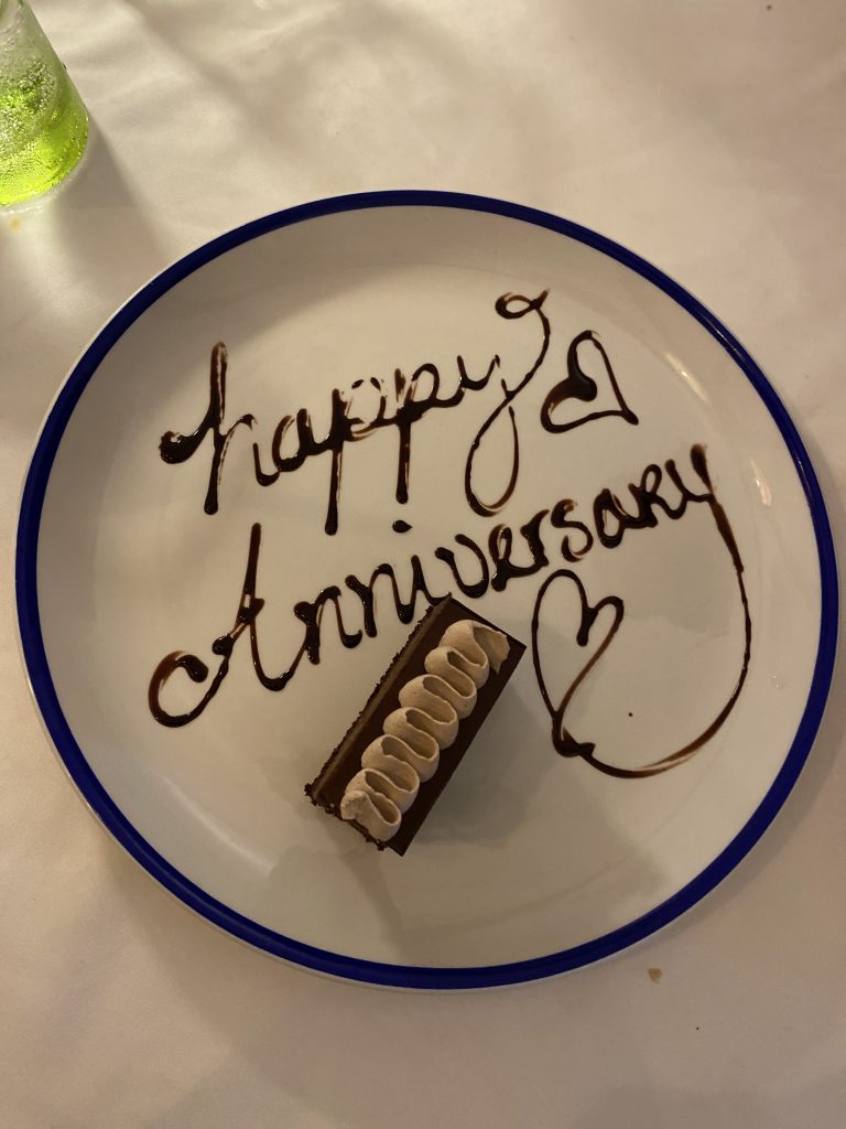 dessert with "Happy Anniversary" spelled out in chocolate