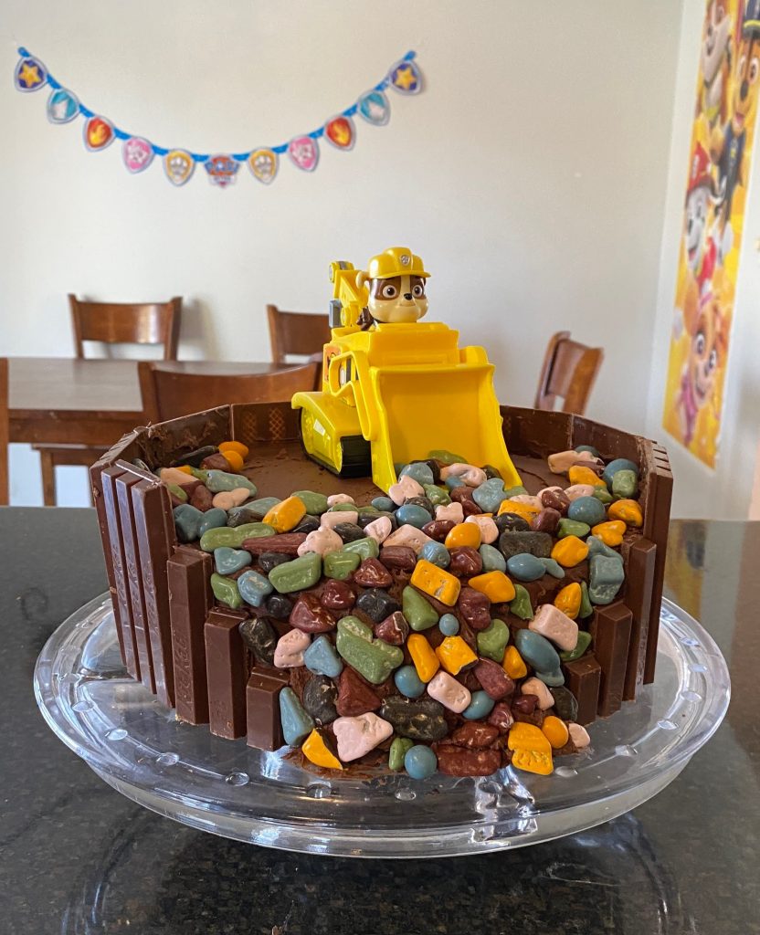 Paw Patrol birthday cake with Rubble and his bulldozer scooping candy rocks