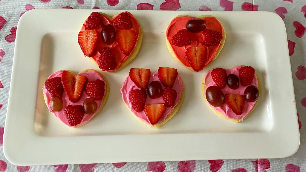 Mini heart fruit pizza cookies on white platter